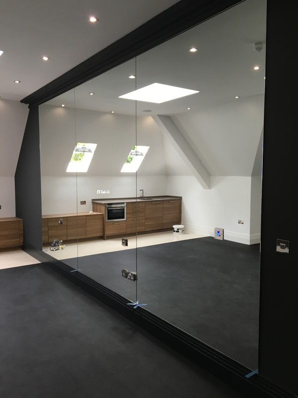 Frameless glass partition in loft conversion by Moorgate glaziers